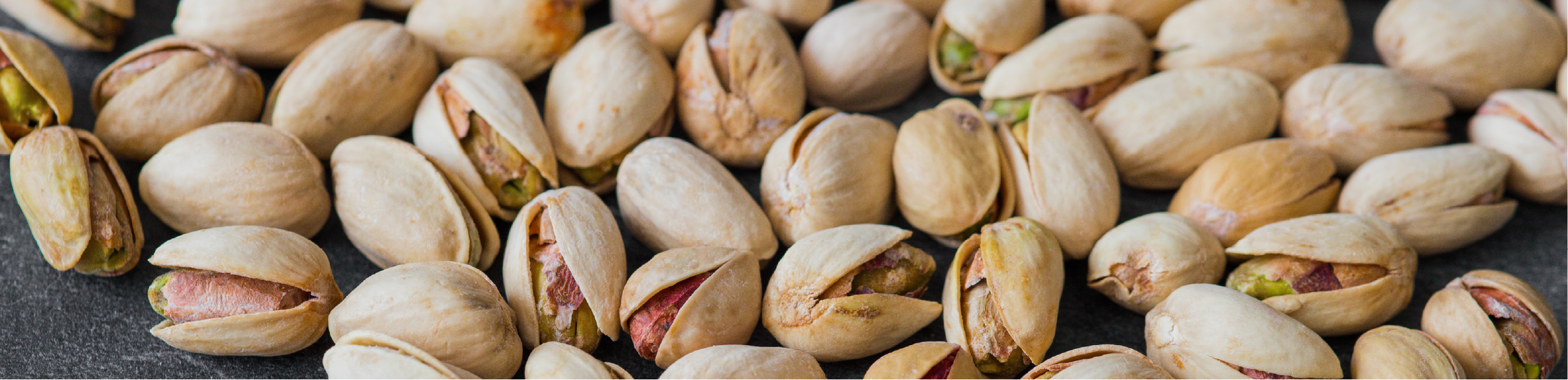 pistachio nuts in shells on a black slate board