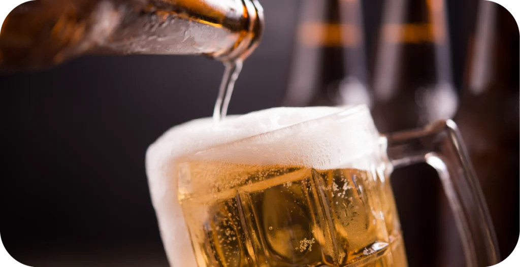 A bottle of beer is poured into a glass. Beer is one of the many products that should be subjected to Food Constituent Testing
