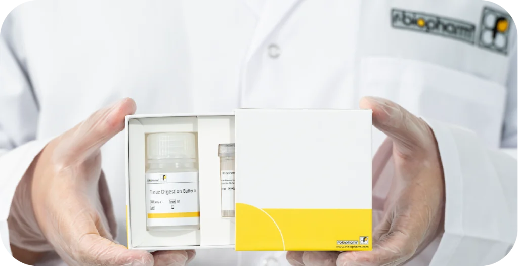 a man in an R-Biopharm branded lab coat holds a box containing reagents for a Tissue Digestion Kit box used for dermatophyte testing