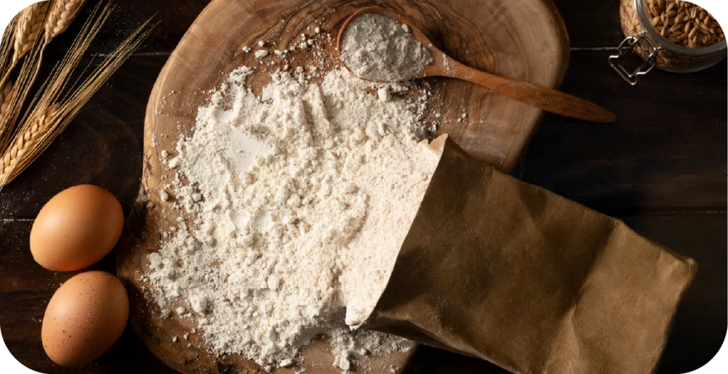 a bag of flour spills out onto a chopping board
