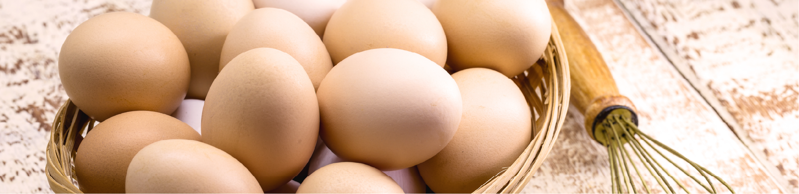 a number of eggs in a basket on a wooden bench