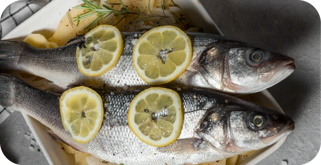 raw, whole fish for fish allergen testing placed on a plate with lemon slices and herbs