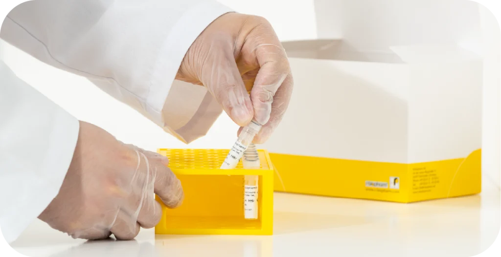 a man in a lab coat places a tube of liquid into a tray used for gastrointestinal testing