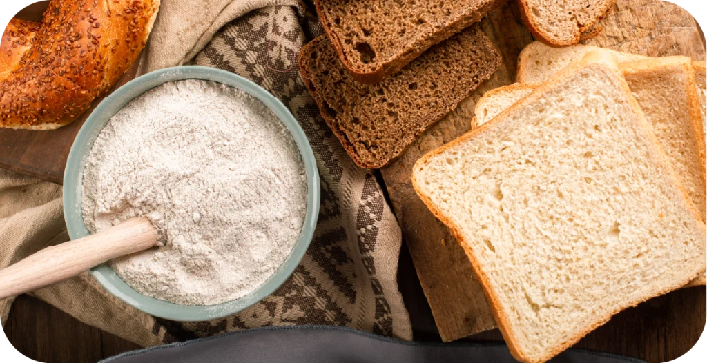 an assortment of products for gluten testing, including bread, flour and other wheat-based items on a wooden chopping board