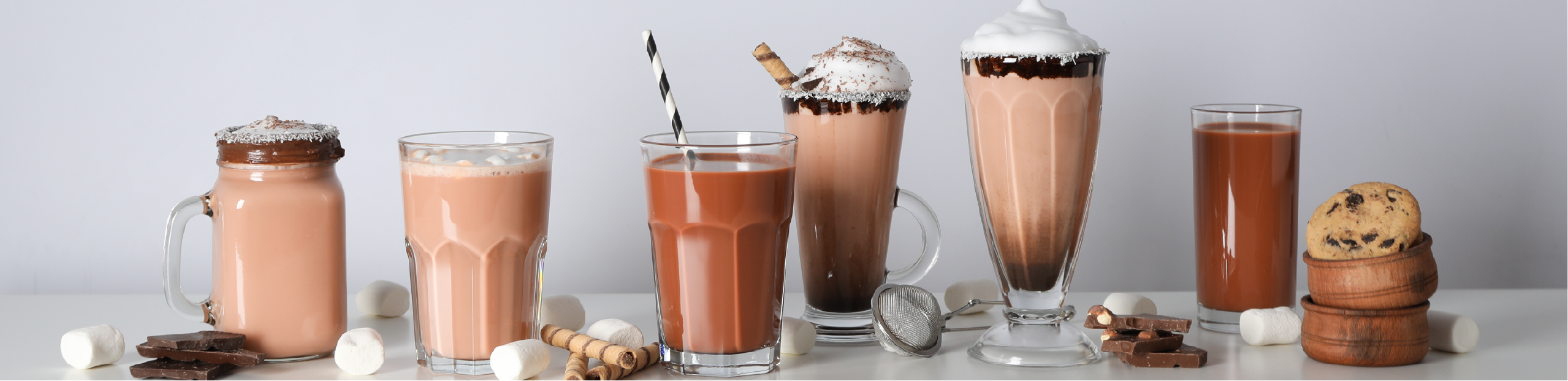 a series of chocolate milkshakes on a bench