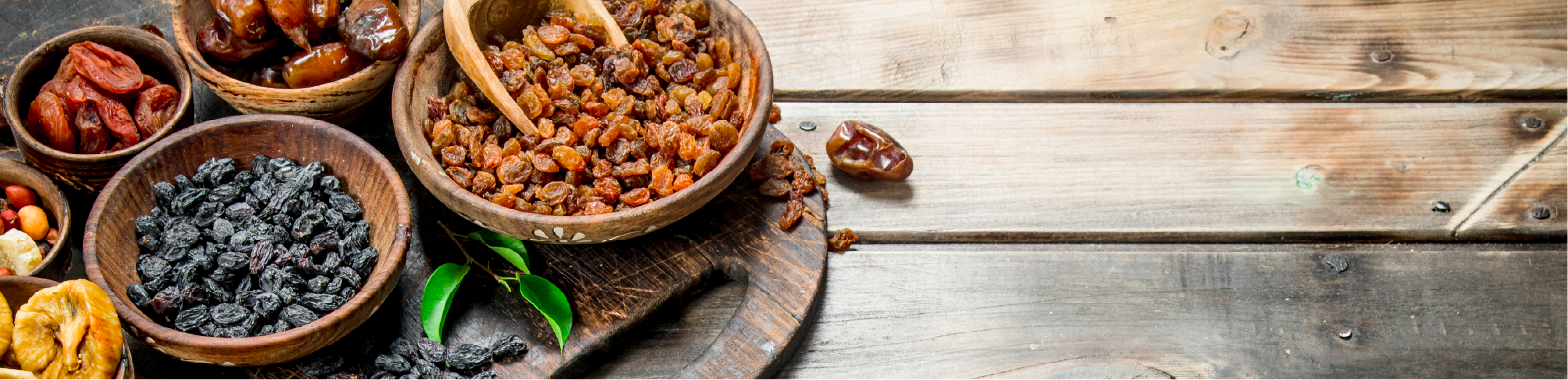 dried fruits and nuts arranged on a chopping board on a wooden table