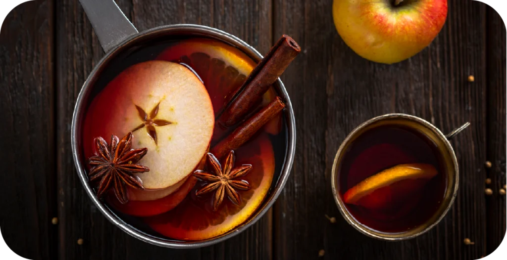 a glass of mulled wine with fresh fruit, cinnamon and star anise