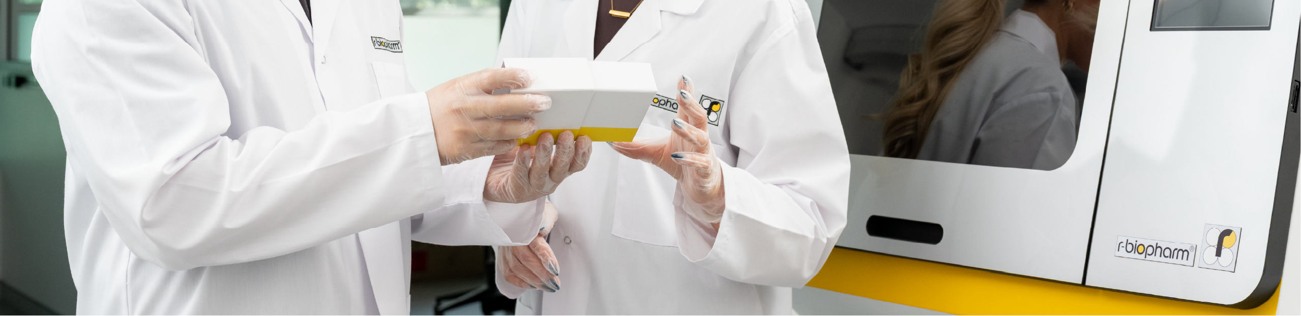 two scientists inspect a RIDA®Prep Tissue Digestion Kit in front of a RIDA®Xtract 24 instrument