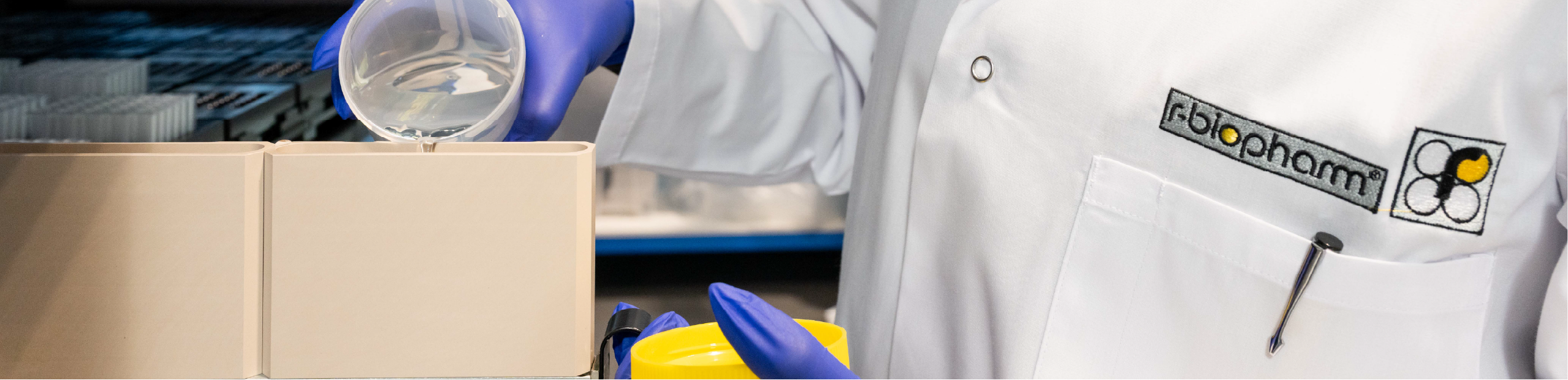a woman in a lab coat pours liquid into a machine in preparation for performing a RIDA®Xtract 24 Blood DNA Kit test