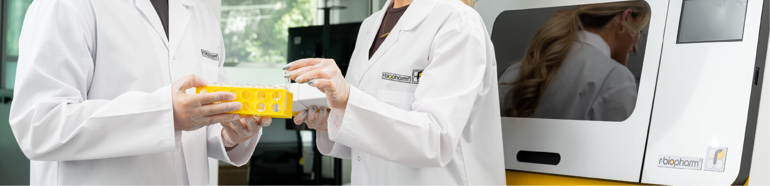 two scientists holding medical diagnostics next to a RIDA®Xtract 24