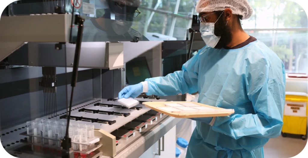 a man in a lab coat using a piece of scientific equipment to conduct urinary tract infection testing