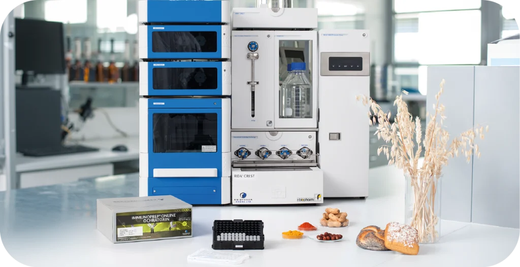 The full solution for the CHRONECT Symbiosis RIDA®CREST, including a large blue machine with dark grey windows, a large white machine and some tests and some wheat