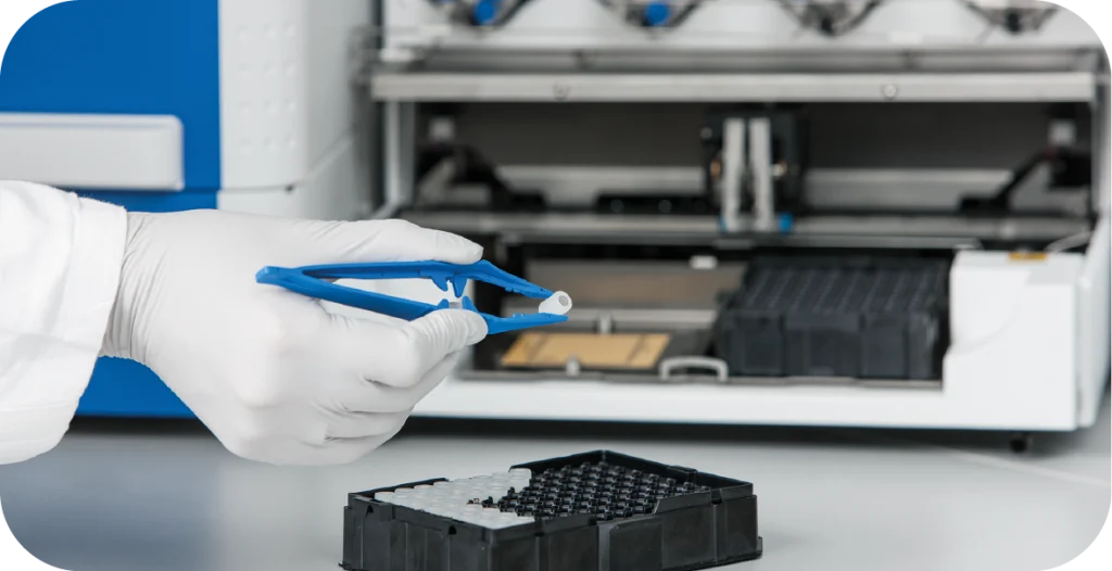 a scientist inserts a small tube into a complex diagnostic machine