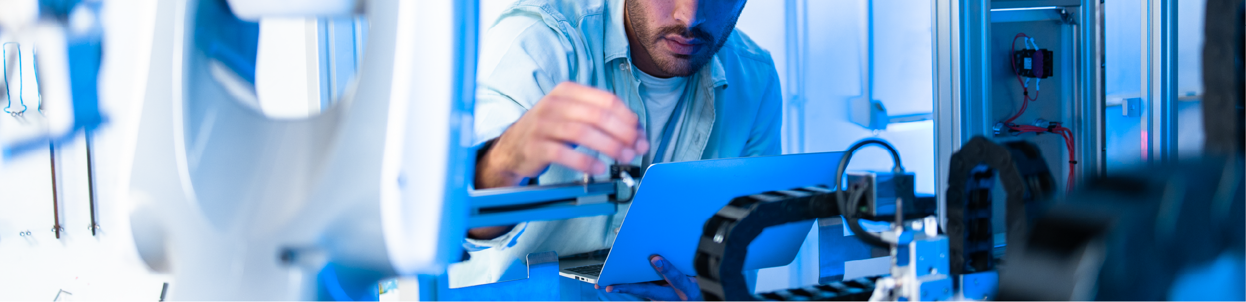 a man in a lab coat analyses scientific results on a laptop in a lab