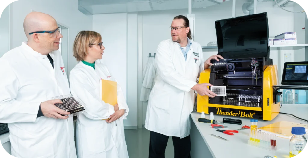 Three scientists working with a ThunderBolt® machine